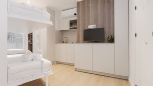 A compact room with a bunk bed, kitchenette, and a flat-screen TV. - Txapitela Rooms - Perfect for 2 (Pamplona)