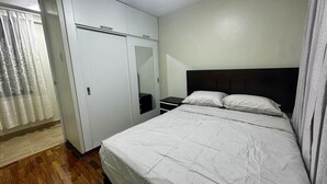 Une chambre à coucher avec un lit, une armoire et un miroir.