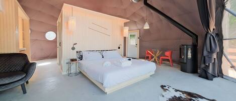Quarto com cama, cadeira, mesa e aquecedor.