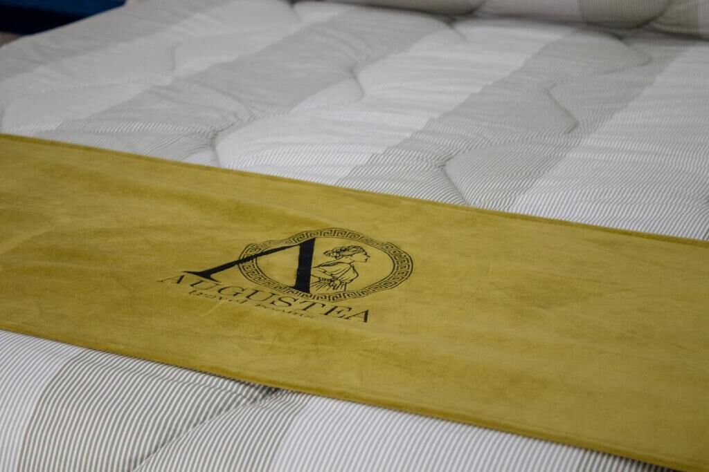 A bed with a yellow headboard and a logo on it.