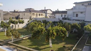 A residential area with houses, a garden with trees, and a pathway. - Augustea Travel (San Marcellino)