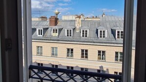A view from a window of a building with multiple windows and a balcony railing. - HOTEL LA LOUISIANE (Paris)