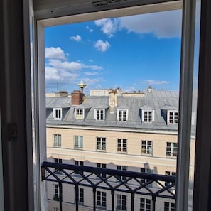 A view from a window of a building with multiple windows and a balcony railing. - HOTEL LA LOUISIANE (Paris)