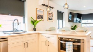 Eine moderne Küche mit Geschirrspüler, Spüle und Fenster.