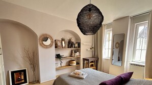 A bedroom with a bed, a hanging light fixture, a mirror, and a window. - Quiet 2-bdrm flat in central Strasbourg (Strasbourg)
