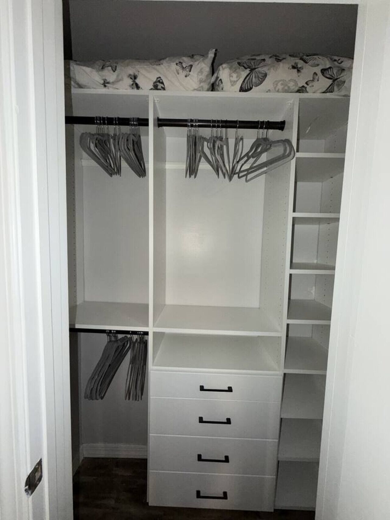Um closet espaçoso com prateleiras abertas, espaço para pendurar roupas e gavetas.