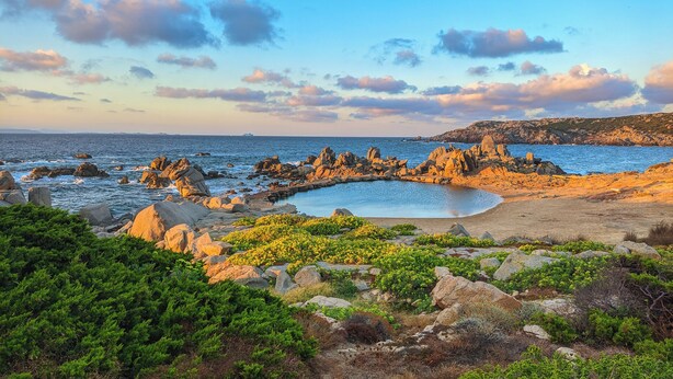 A coastal landscape with rocky formations, a beach, and green vegetation. - Casa Audrey by Wonderful Italy (Santa Teresa di Gallura)