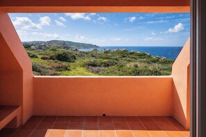 A balcony with a view of a coastal landscape, including greenery and the sea. - Casa Audrey by Wonderful Italy (Santa Teresa di Gallura)