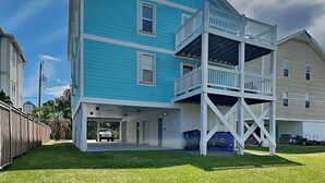 Un edificio de dos pisos con garaje cubierto y balcón.