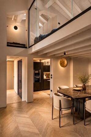 A modern interior with a dining area, kitchen, and a loft space. - THE PENTHOUSE by ASTRA COLLECTION (Bologna)