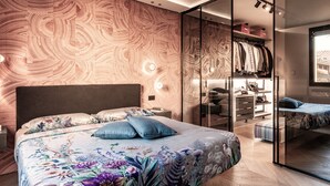 Een moderne slaapkamer met een groot bed, een inloopkast en een glazen scheiding.