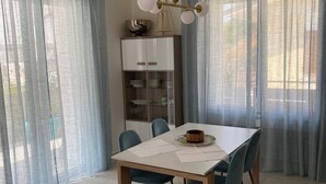 A dining area with a table, chairs, a chandelier, and a cabinet with dishes. - Villa Luigia Garda. "Azure" (Peschiera del Garda)