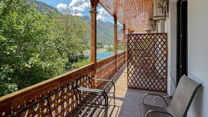 A wooden balcony with a lattice partition, a bench, and a chair. - River Front Mtskheta (Mtskheta)