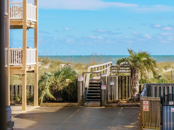 A wooden gate leading to a beach area with a view of the ocean. - Sand Pebbles #A3 - Pelican Perch (Carolina Beach)