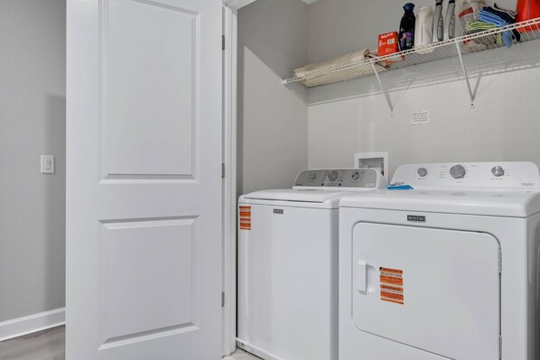 A laundry room with a white door, a Maytag washer, and a dryer. - Lake View 9BR Mansion - Theater, Pool & Disney Themes (Kissimmee)