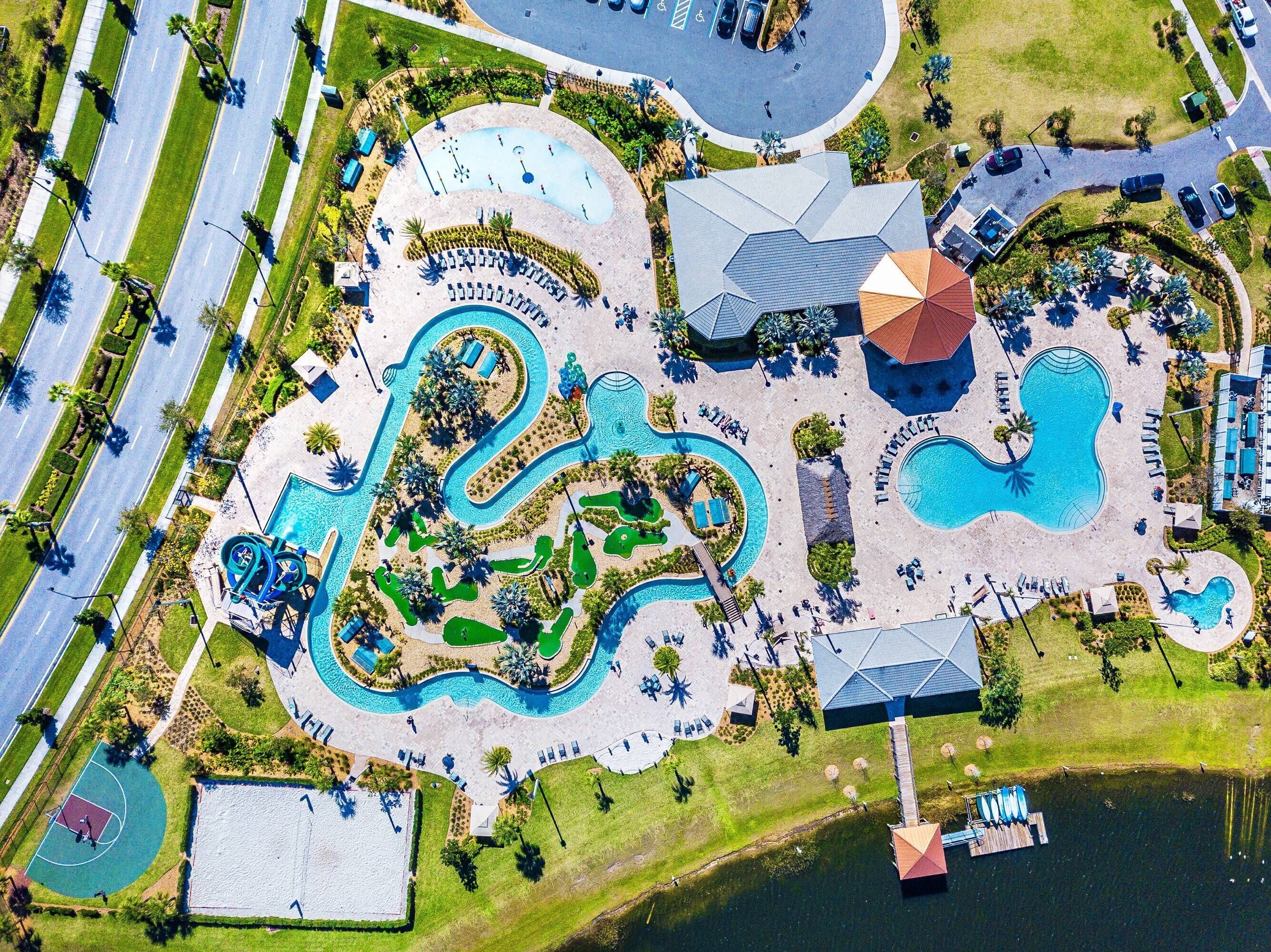 Eine Vogelperspektive zeigt ein Resort mit Wasserpark, großem Pool und Basketballfeld.