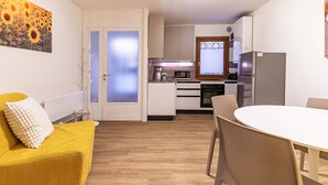 A modern kitchen with white cabinets, a microwave, and a refrigerator. - Daisy Flowers by Wonderful Italy (Venice)