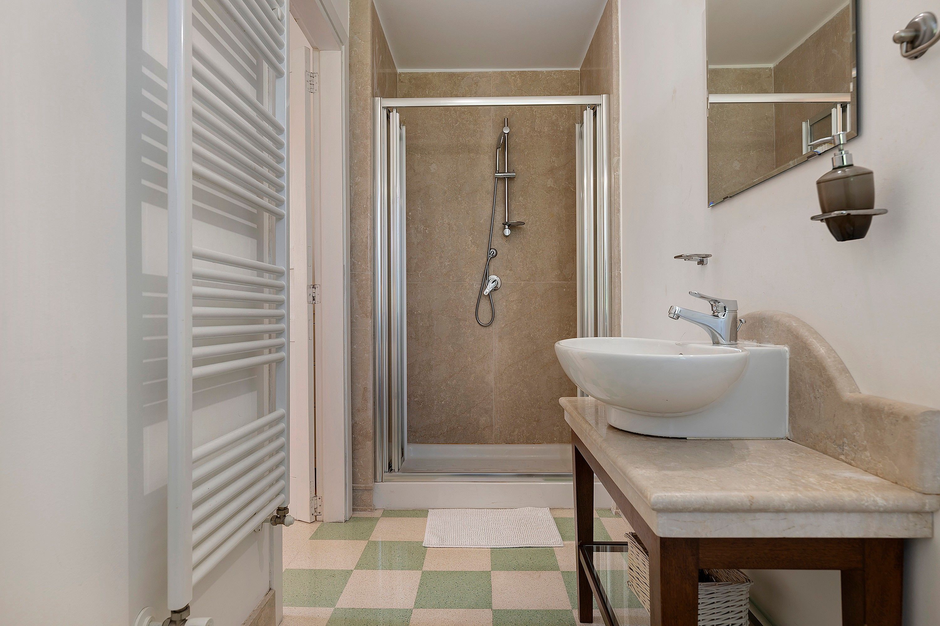 A bathroom with a shower, a sink, and a mirror.