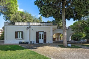 A building with a white facade, a balcony, and a door with shutters. - Villa 'Luciana' with Private Terrace, Wi-Fi, and Air Conditioning (Martina Franca)