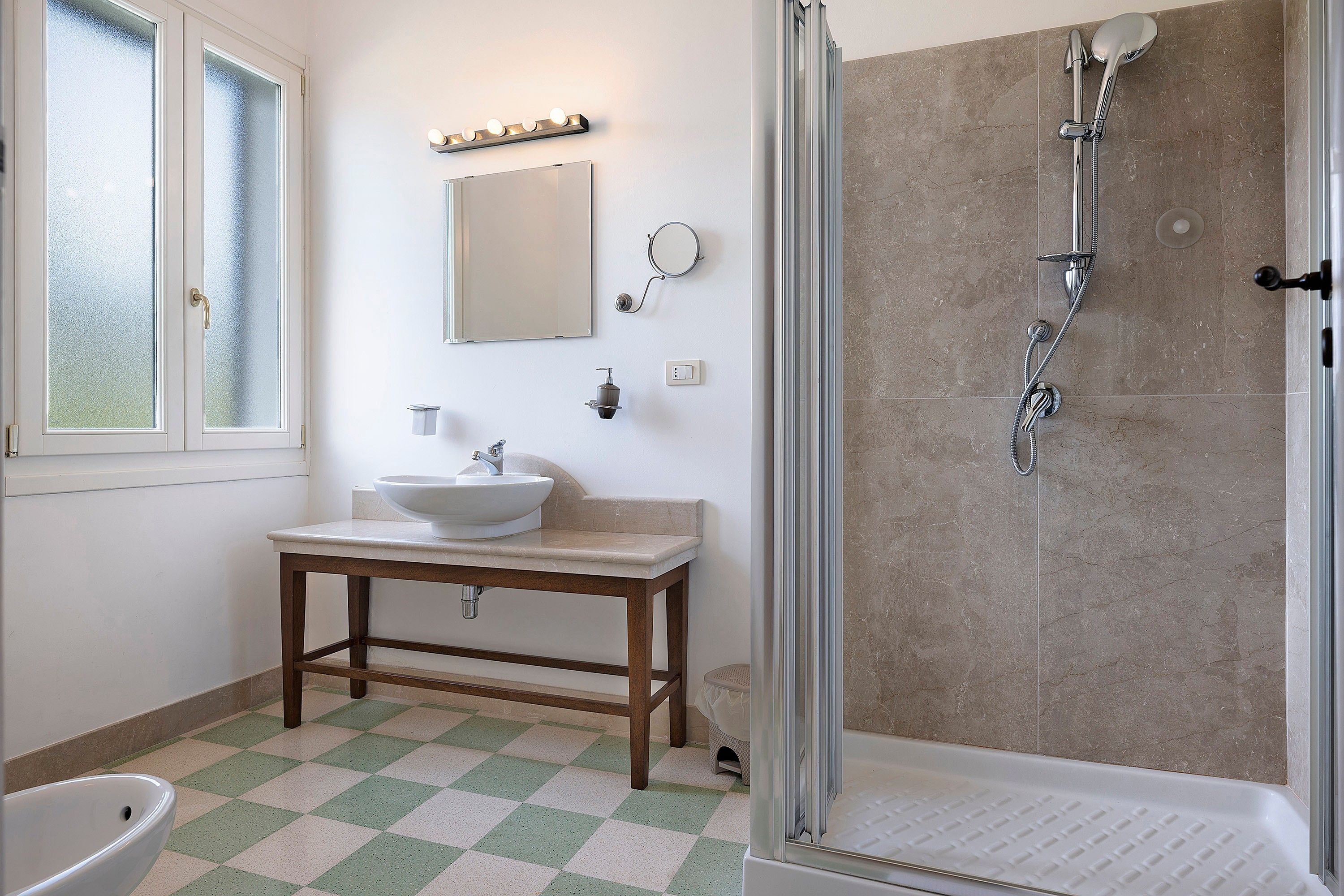 Ein Badezimmer mit Waschbecken, Spiegel und Dusche.