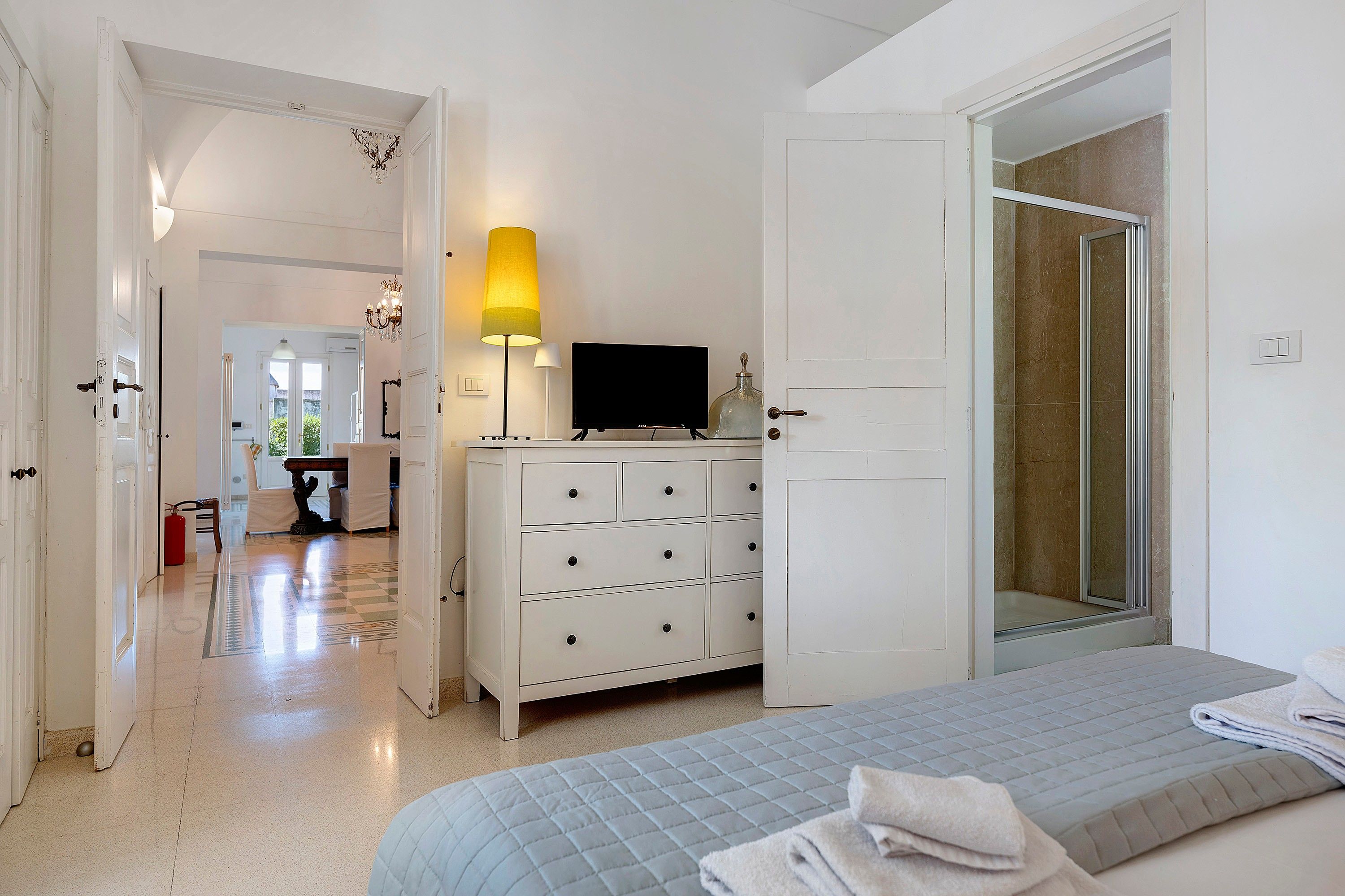 Een hotelkamer met een bed, een dressoir, een televisie en een badkamers deur.