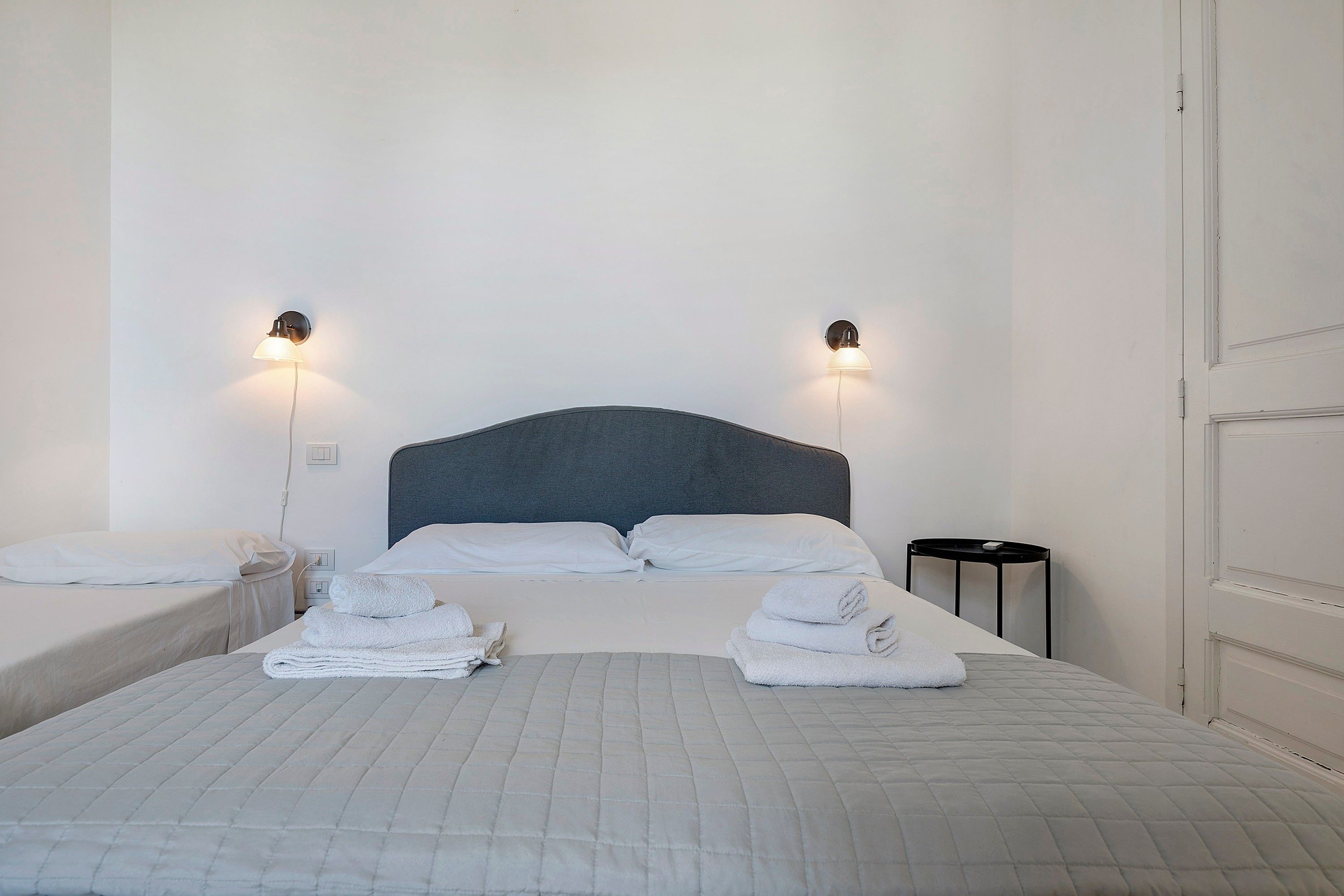 Ein Hotelzimmer mit einem Bett, zwei Nachttischen und zwei Wandlampen.