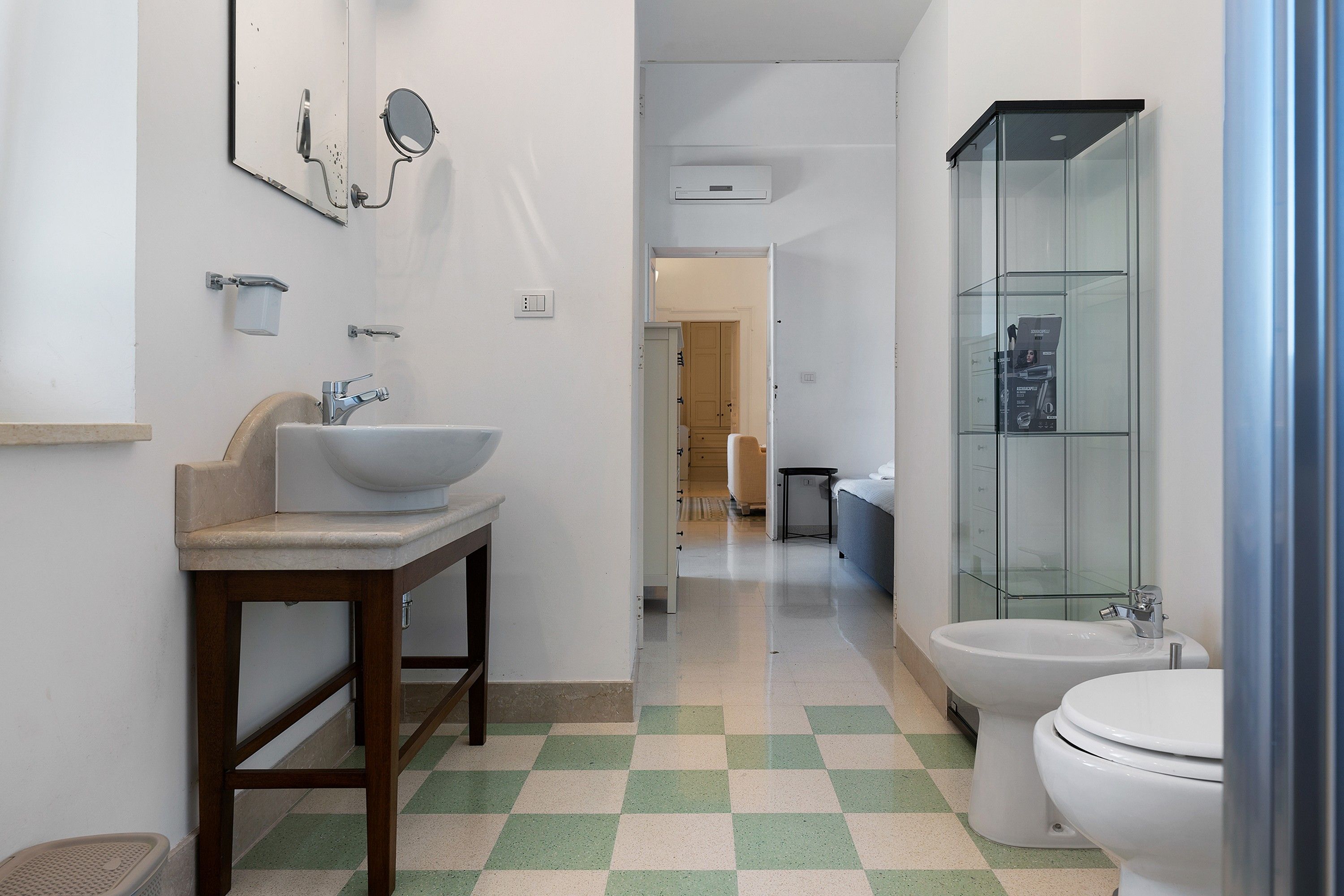 A bathroom with a sink, mirror, toilet, and shower.