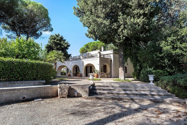 A building with a symmetrical facade, arched doorways, and a central balcony. - Villa 'Luciana' with Private Terrace, Wi-Fi, and Air Conditioning (Martina Franca)