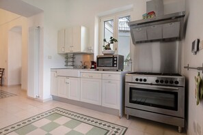 A kitchen with white cabinets, a built-in oven, a microwave, and a stove. - Villa 'Luciana' with Private Terrace, Wi-Fi, and Air Conditioning (Martina Franca)