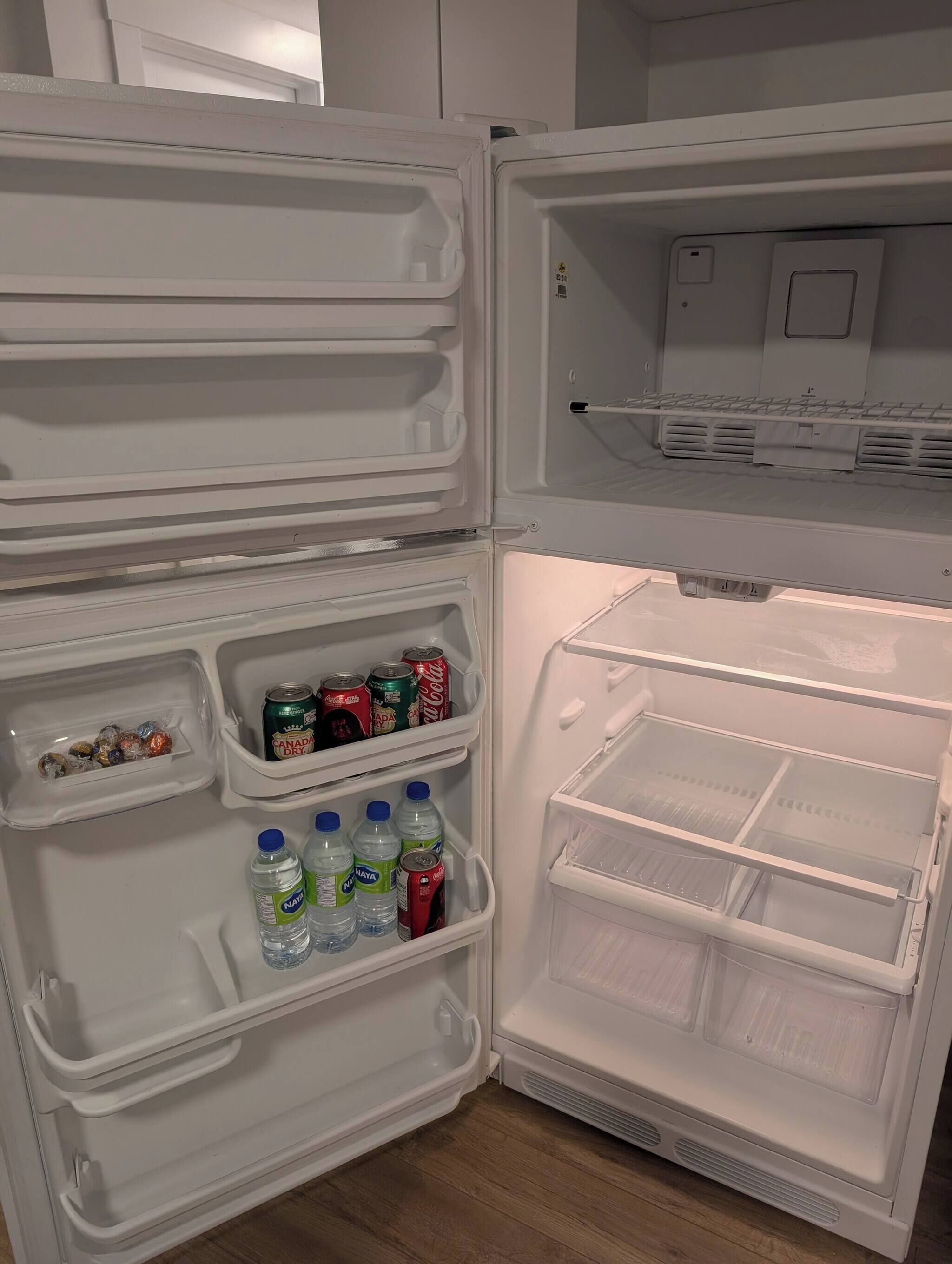 Un refrigerador obert amb prestatges que contenen begudes i aperitius.