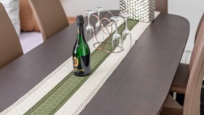 A table with a bottle of Metternich champagne, glasses, and a striped table runner. - Cozy Apartment in Willingen, Usseln – Lovingly Furnished for a Relaxing Atmosphere (Willingen (Upland))