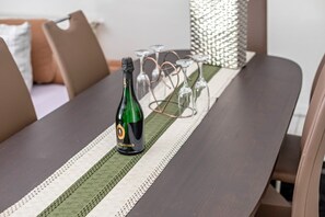 Una mesa con una botella de champán Metternich, copas y un camino de mesa a rayas.