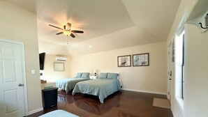 A bedroom with two beds, a ceiling fan, a TV, and artwork on the wall. - Tiny home in lovely Rockport TX-Frigate House #2 (Rockport)