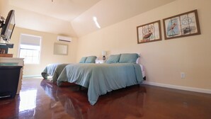 A bedroom with two beds, a ceiling fan, and artwork on the walls. - Tiny home in lovely Rockport TX-Frigate House #2 (Rockport)