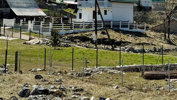 A rural village with houses, a fenced area, and snow-capped mountains in the background. - Cabin Varde | 2-bedroom cabin in charming Žabljak (Žabljak)