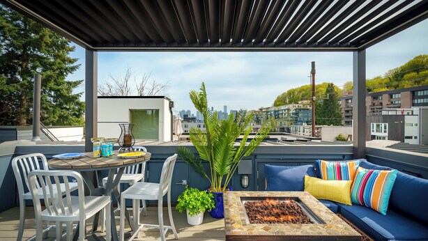 An outdoor patio with seating, a fire pit, and a view of the city skyline. - Obermiller House ~ Spectacular Sunset~Modern~Rooftop~AC+Games+Parking (Seattle)