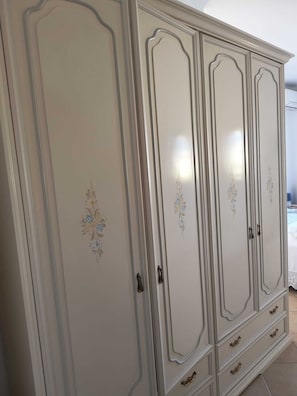 A large, light-colored wardrobe with decorative floral patterns and multiple drawers. - Casa MARES, an oasis of relaxation and comfort ten minutes from the center of Olbia (Olbia)