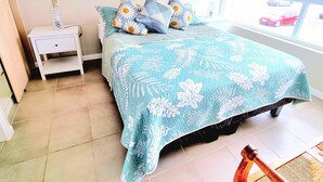 Une chambre à coucher avec un lit, une table de chevet et une fenêtre donnant sur une voiture.
