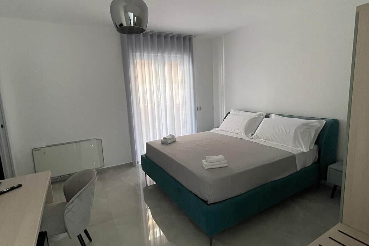 Una habitación de hotel moderna con una cama, un escritorio y una silla.