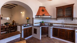 Una cocina con armarios de madera, salpicadero de azulejos y una isla central.