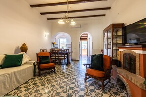 A living room with a sofa, two armchairs, a fireplace, and a television. - La Palommella - Sant'Agata sui Due Golfi (Massa Lubrense)