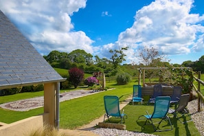 A garden with a pergola, outdoor seating, and a well-maintained lawn. - Guest Room 'Chambre Mer' with Shared Terrace, Communal Garden and Wi-Fi (Teurthéville-Bocage)