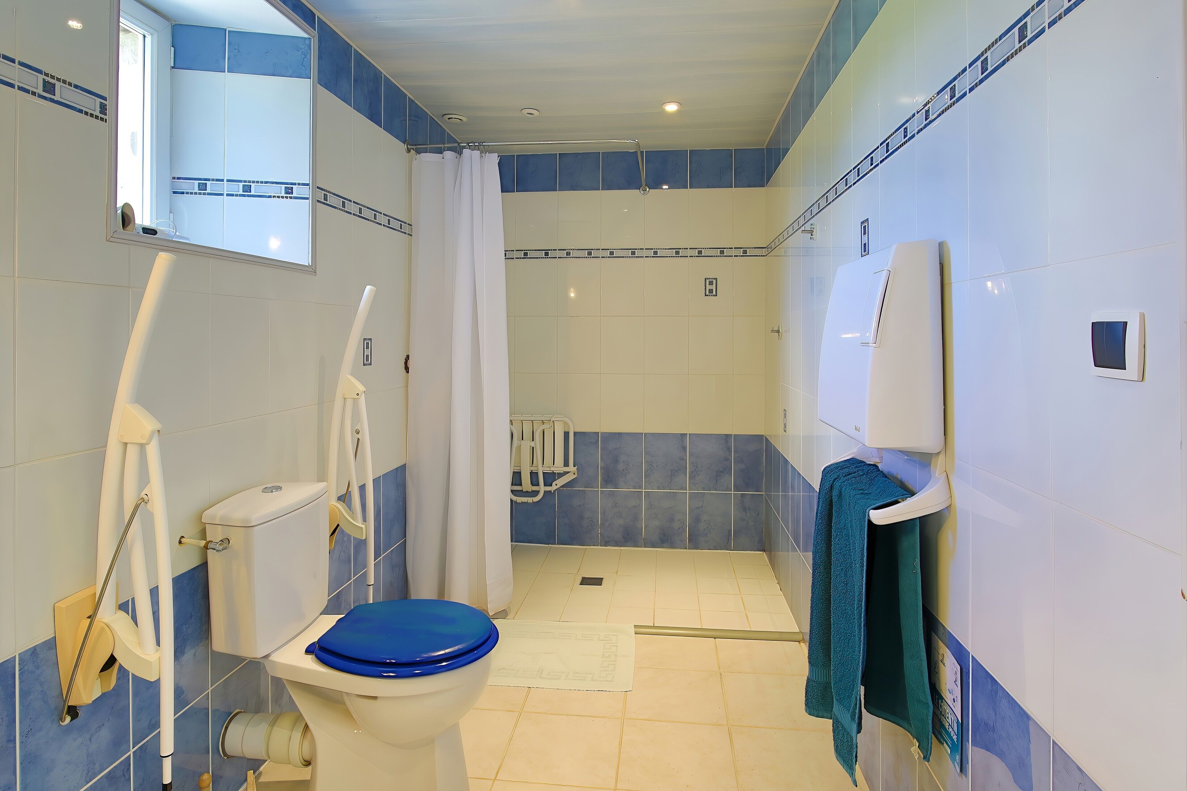 A bathroom with a toilet, shower, and a towel rack.