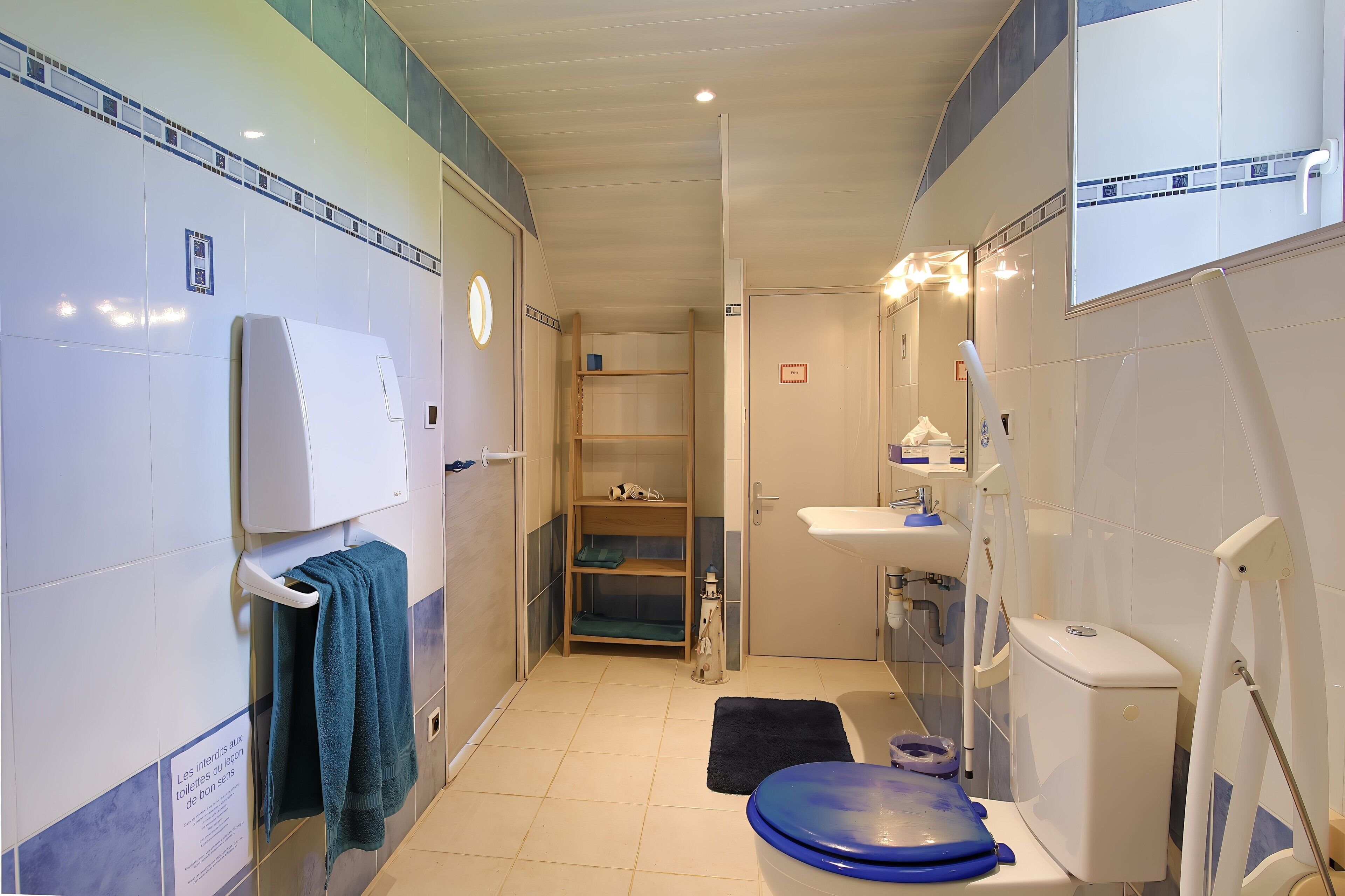Een badkamer met een toilet, wastafel en planken.