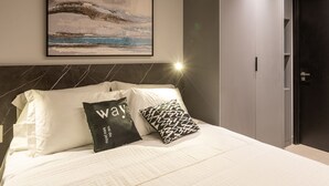 A modern hotel room with a bed, a wall-mounted air conditioner, a painting, and a door. - Way Tambau #R4 - Style and Comfort By Carpediem (João Pessoa)