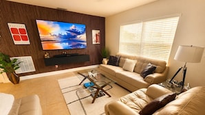 A living room with a sofa, armchair, TV, and a coffee table. - Modern romantic escape designed for comfort. (Jensen Beach)