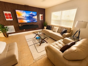 A living room with a sofa, armchair, TV, and a coffee table. - Modern romantic escape designed for comfort. (Jensen Beach)