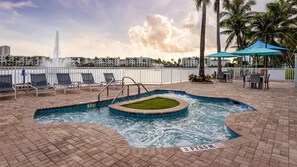 A pool area with lounge chairs, a hot tub, and a view of a distant building. - FIFA World Cup 2026 · Entire Private Villa · Marriott Resort · 8 Guests · Miami (Miami)