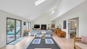 A spacious living area with a fireplace, a TV, and a dining table. - Southampton Retreat, Spacious Family Escape with Heated Pool & Stunning... (Southhampton)