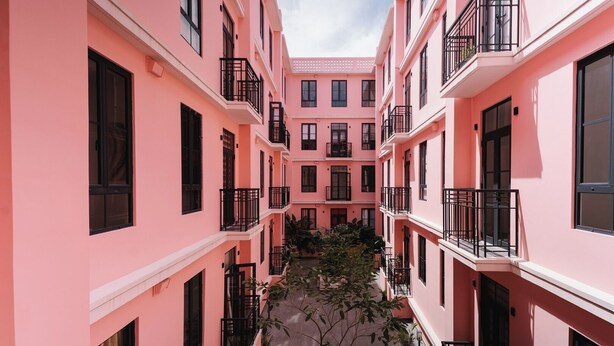 A pink multi-story building with balconies and a central courtyard. - The Glow Stay | Elegant and Modern | @SantaAna (Panama City)